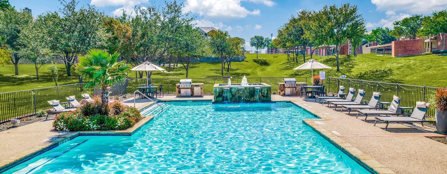 a swimming pool with chairs and umbrellas by it