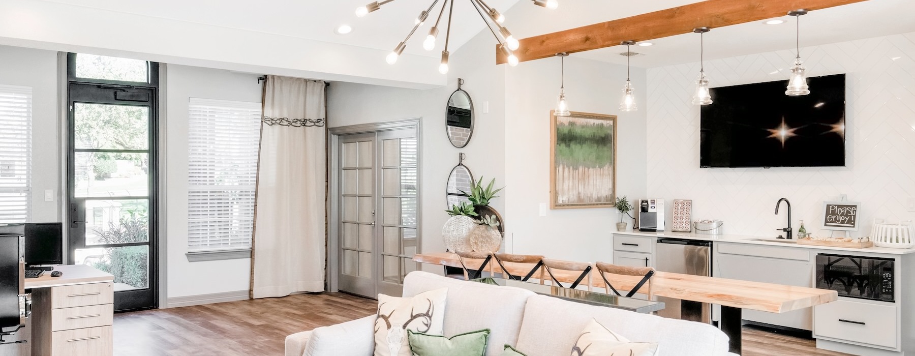 a clubroom with a white couch and a chandelier