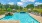 a swimming pool with chairs and umbrellas by it