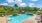 a swimming pool with a fence around it and trees in the back